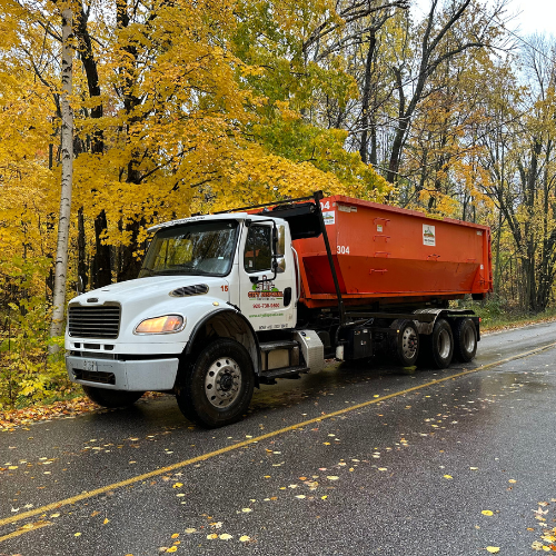 A large orange dumpster with the letter c on it
