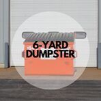 A 6 yard dumpster is sitting in front of a garage door.