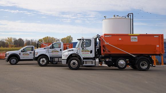 Three trucks are parked next to each other in a parking lot.