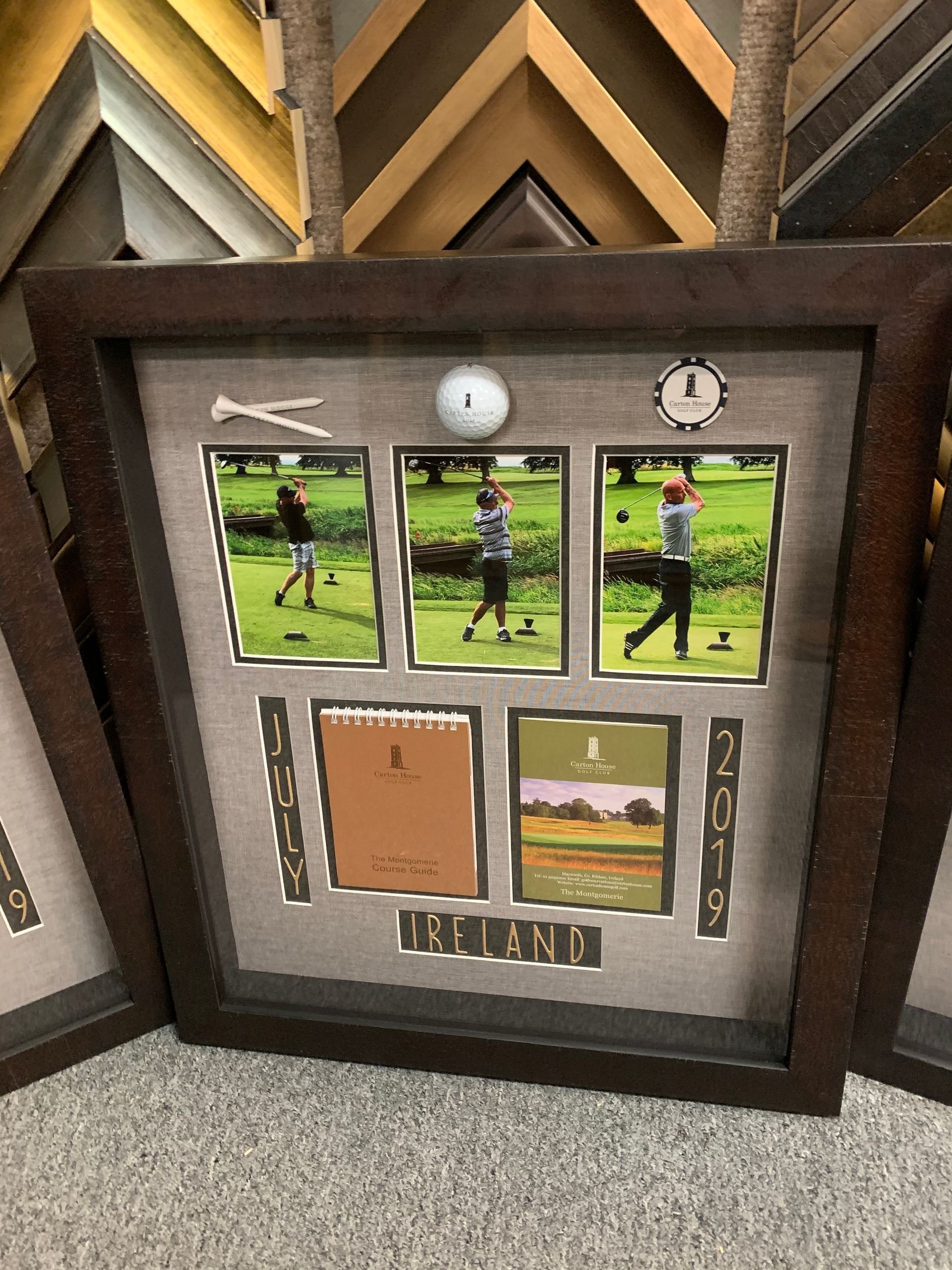 A framed shadowbox display featuring golf photos, a golf ball, tees, and a scoreboard titled 