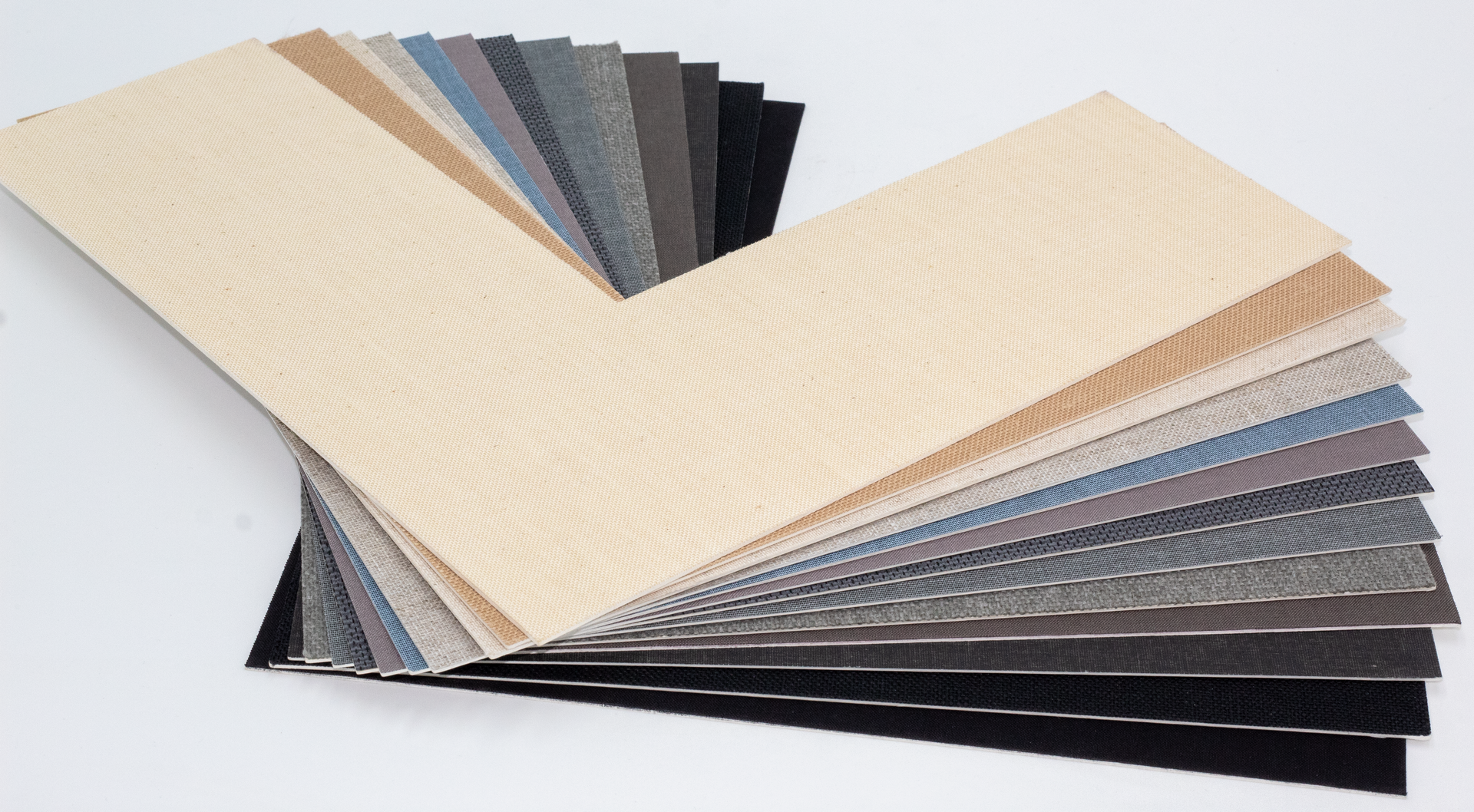 A fan deck of fabric swatches arranged in a color gradient from beige to black, spread out on a white surface.