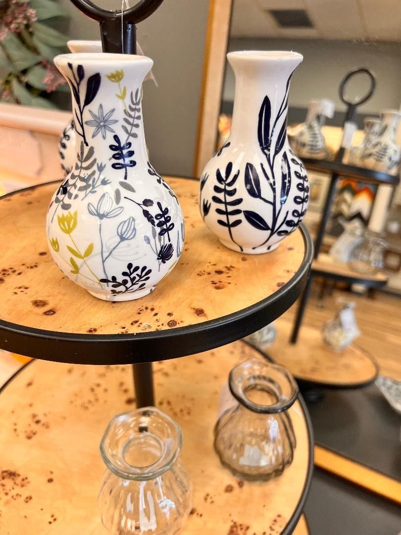 Two small blue-and-white floral vases on a round display shelf in a shop