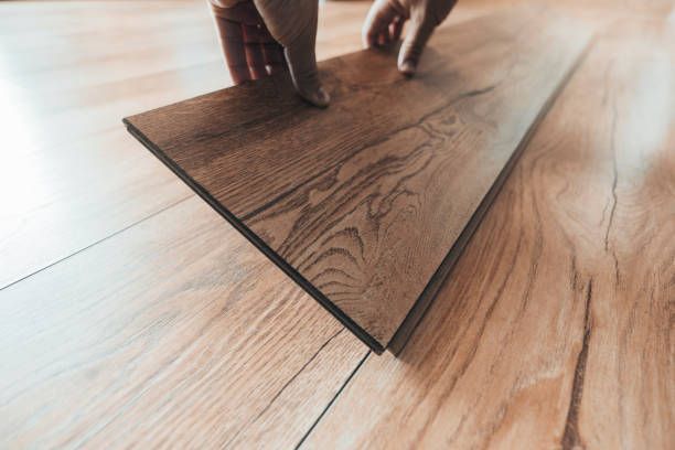 A person is installing a wooden floor.