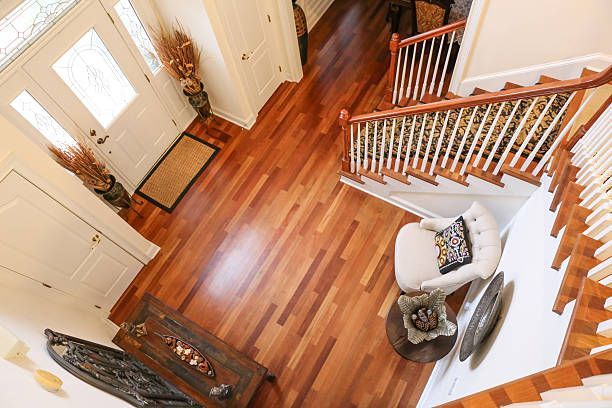 An aerial view of a hallway with hardwood floors and stairs.