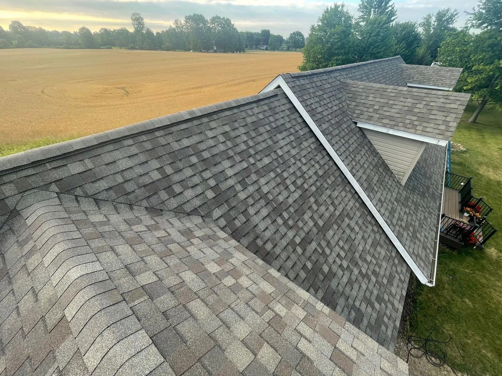A roof covered in gray asphalt shingles with white trim