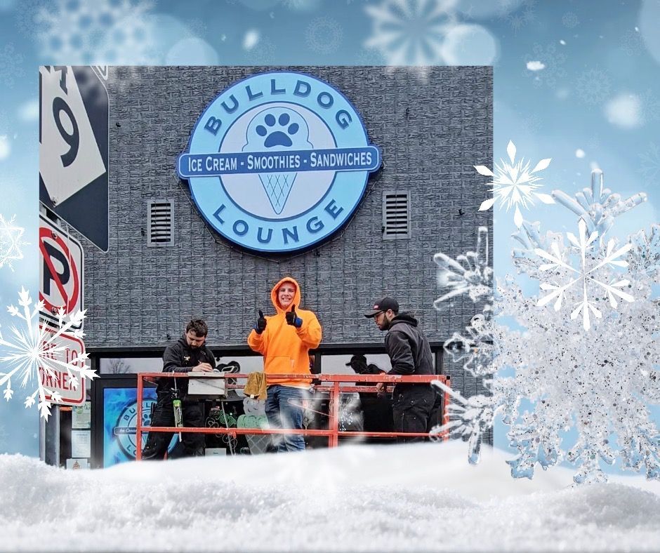Bulldog Lounge with people on a snow-covered deck. Store sign features a paw print and ice cream cone logo.