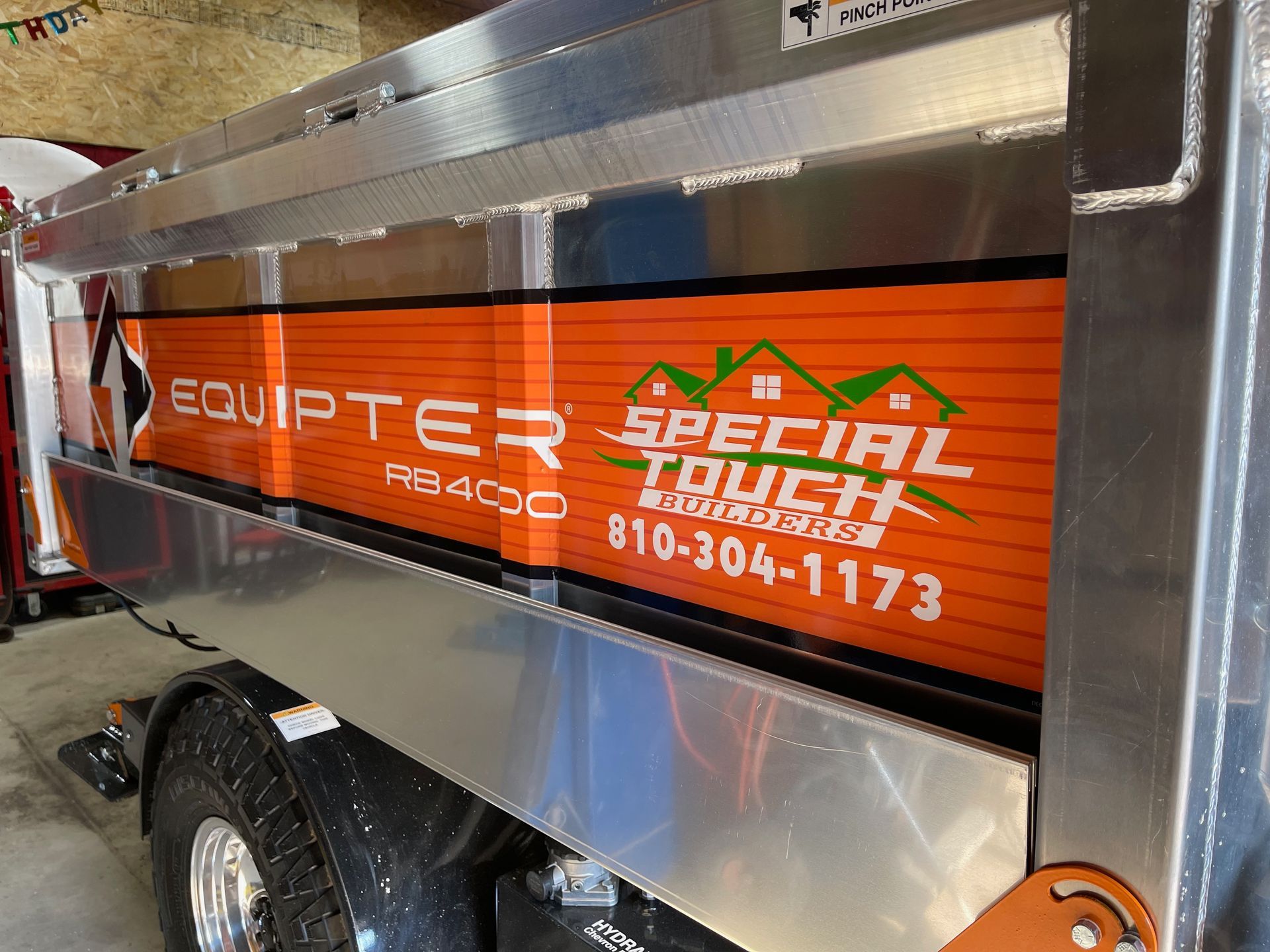 Truck bed with orange Equiptar and Special Touch Builders advertisement. Numbers are visible.