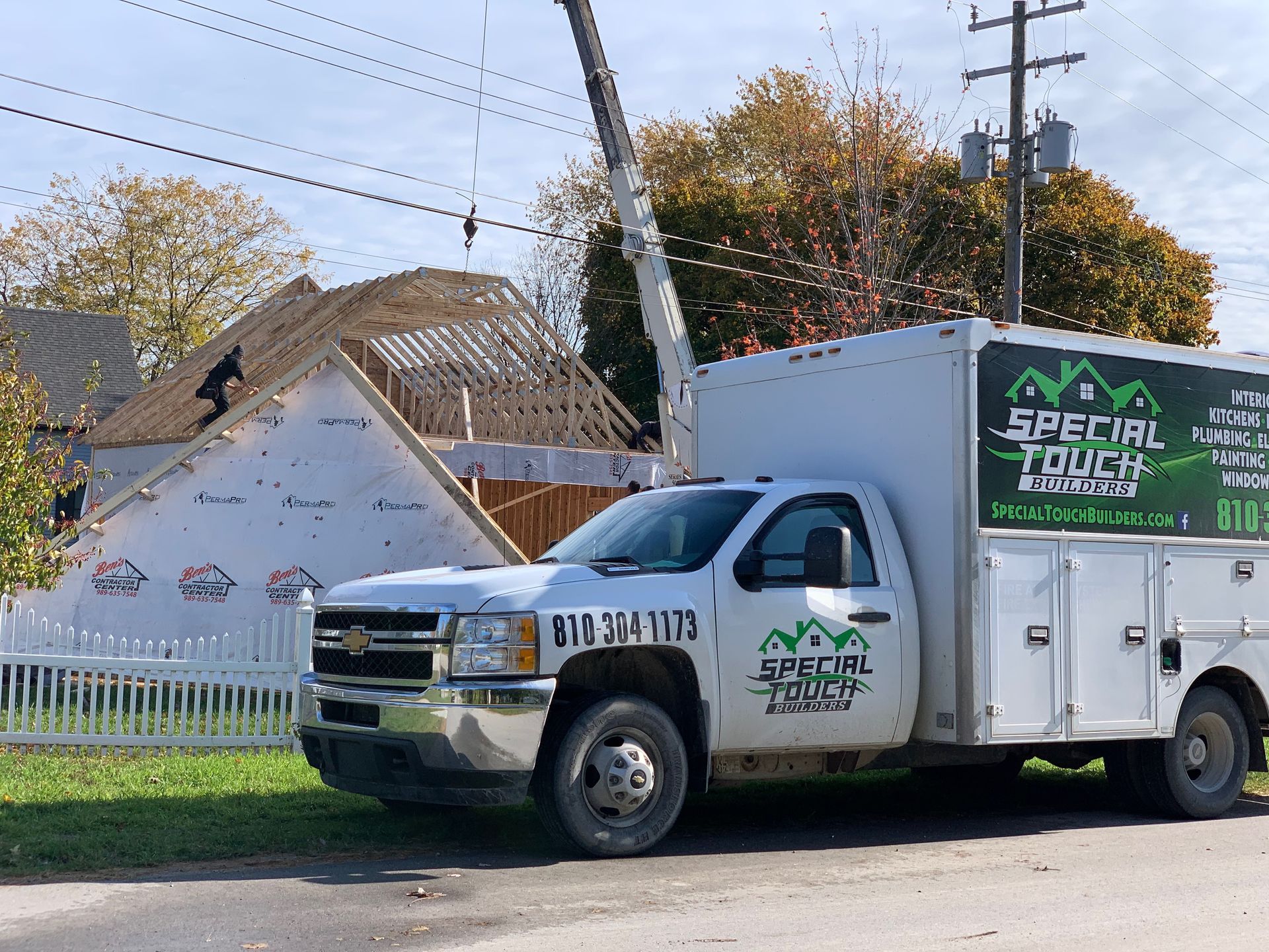 White work truck parked near a house under construction. 
