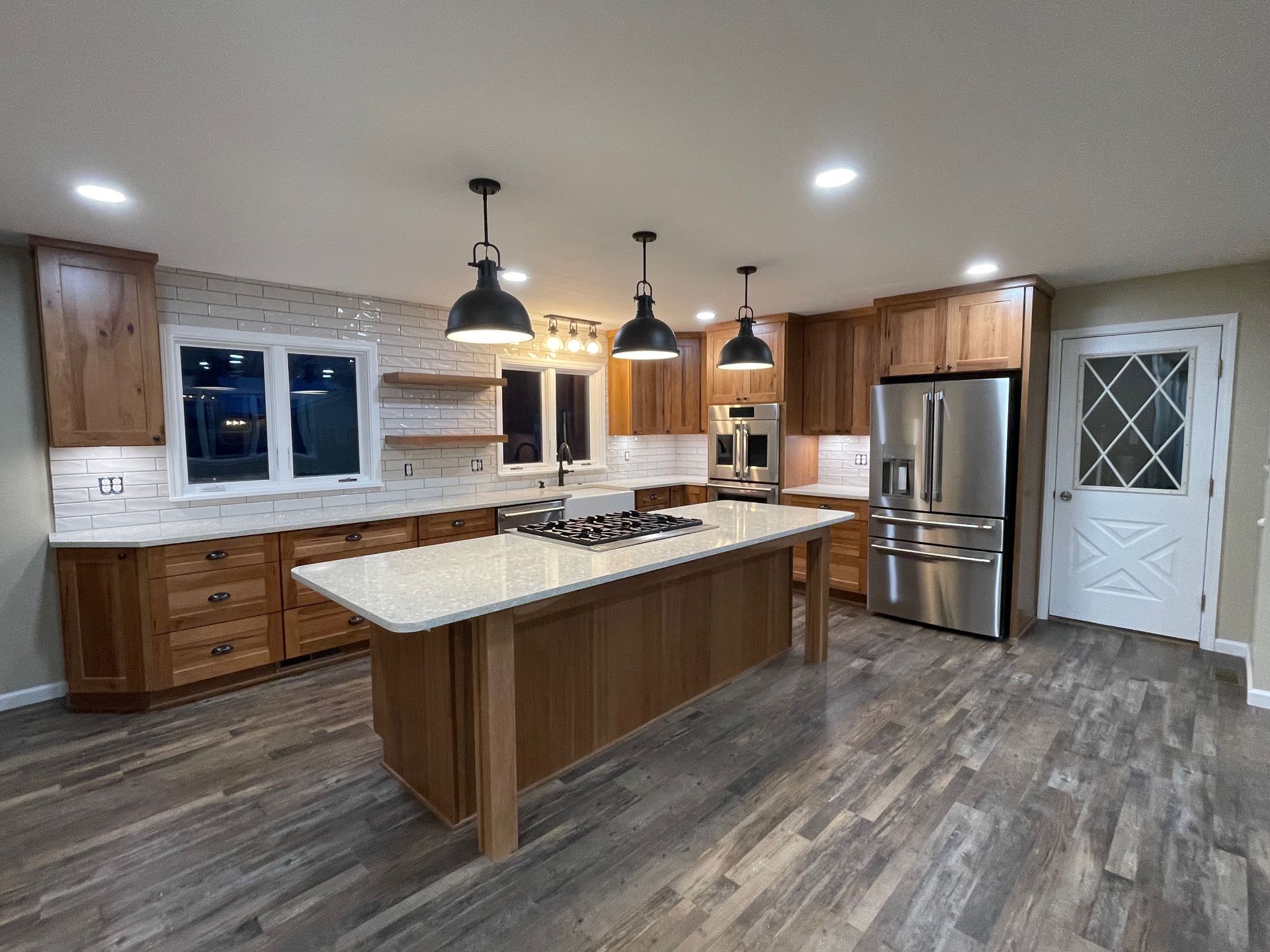 Modern kitchen with wooden cabinets, island, and stainless steel appliances.