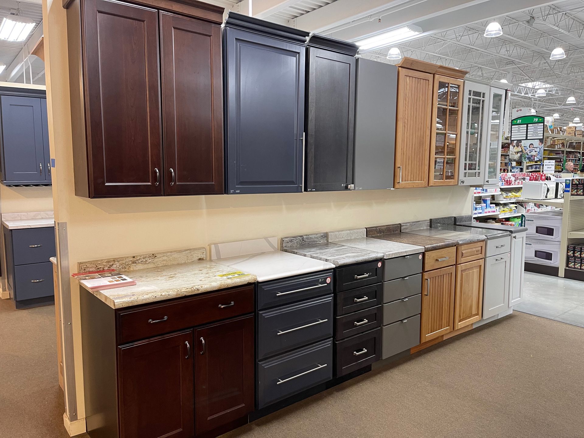 Kitchen cabinet displays in various colors and styles, showcased in a store setting.