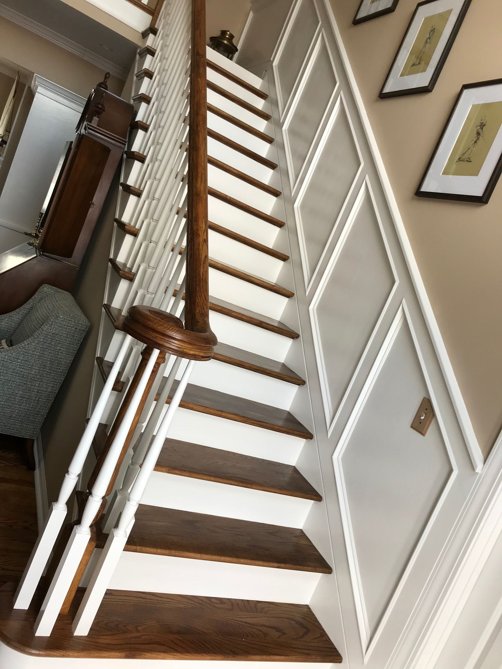 Staircase with white risers and brown treads, white railing, and built-in storage on the wall.