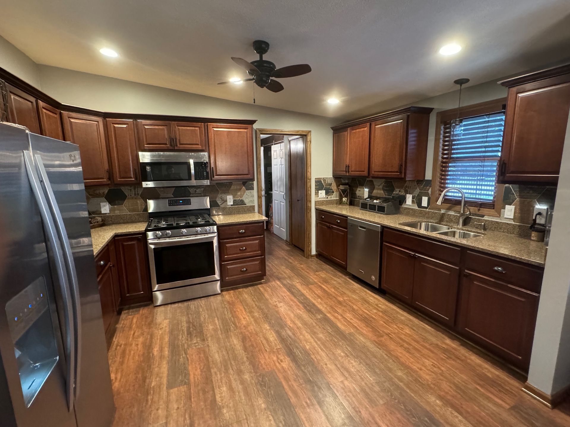 Kitchen with dark wood cabinets, stainless steel appliances, and brown countertops.