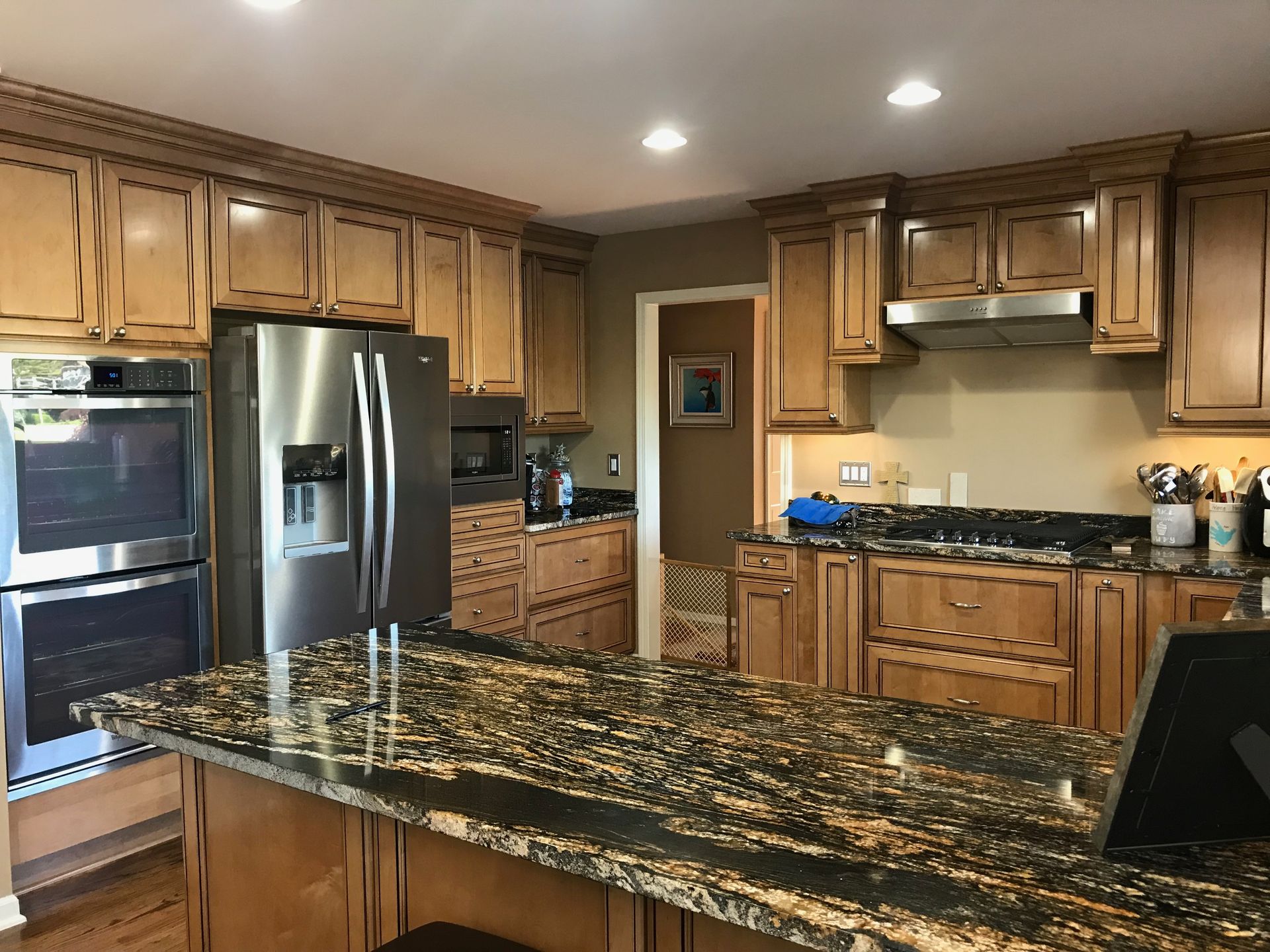 Kitchen with brown cabinets, stainless steel appliances, and granite countertops.