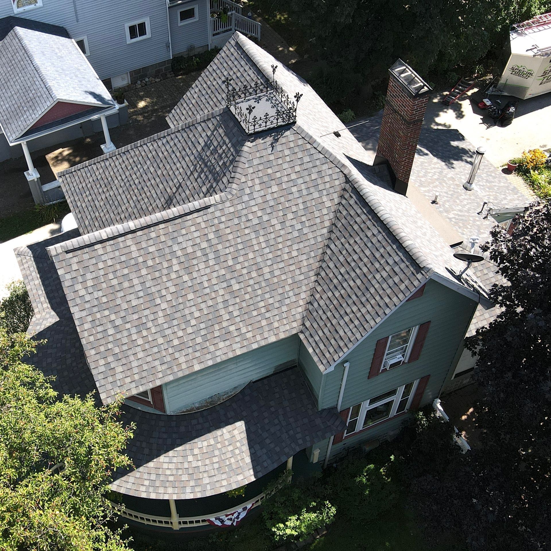 Construction of a wooden roof frame on a building with dormers; overhead view, dusk lighting.