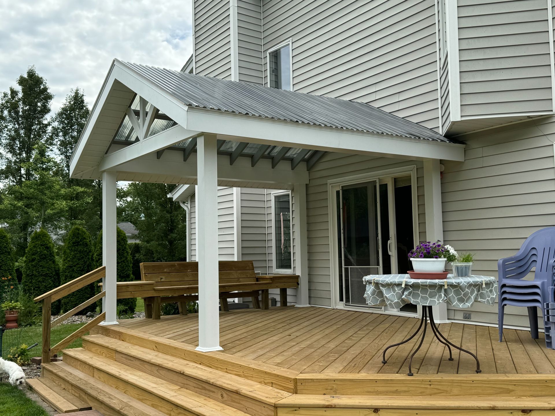 Wooden deck with an attached covered patio and sliding glass door.
