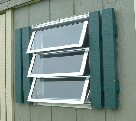 Green house window with three open awning panes and white trim