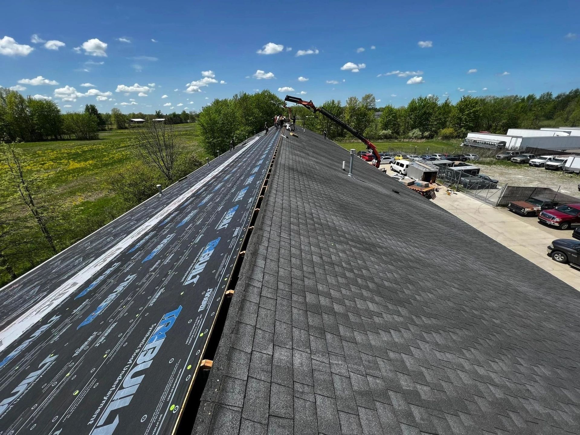 An aerial view of a roof being installed with a crane.