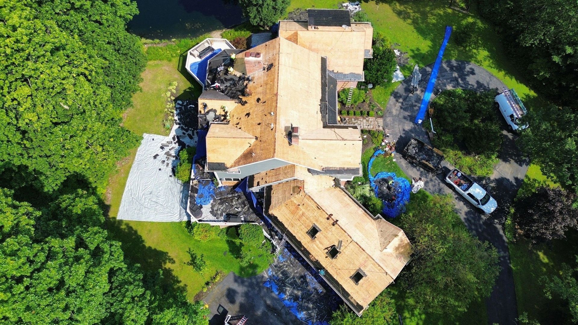 An aerial view of a house under construction surrounded by trees.