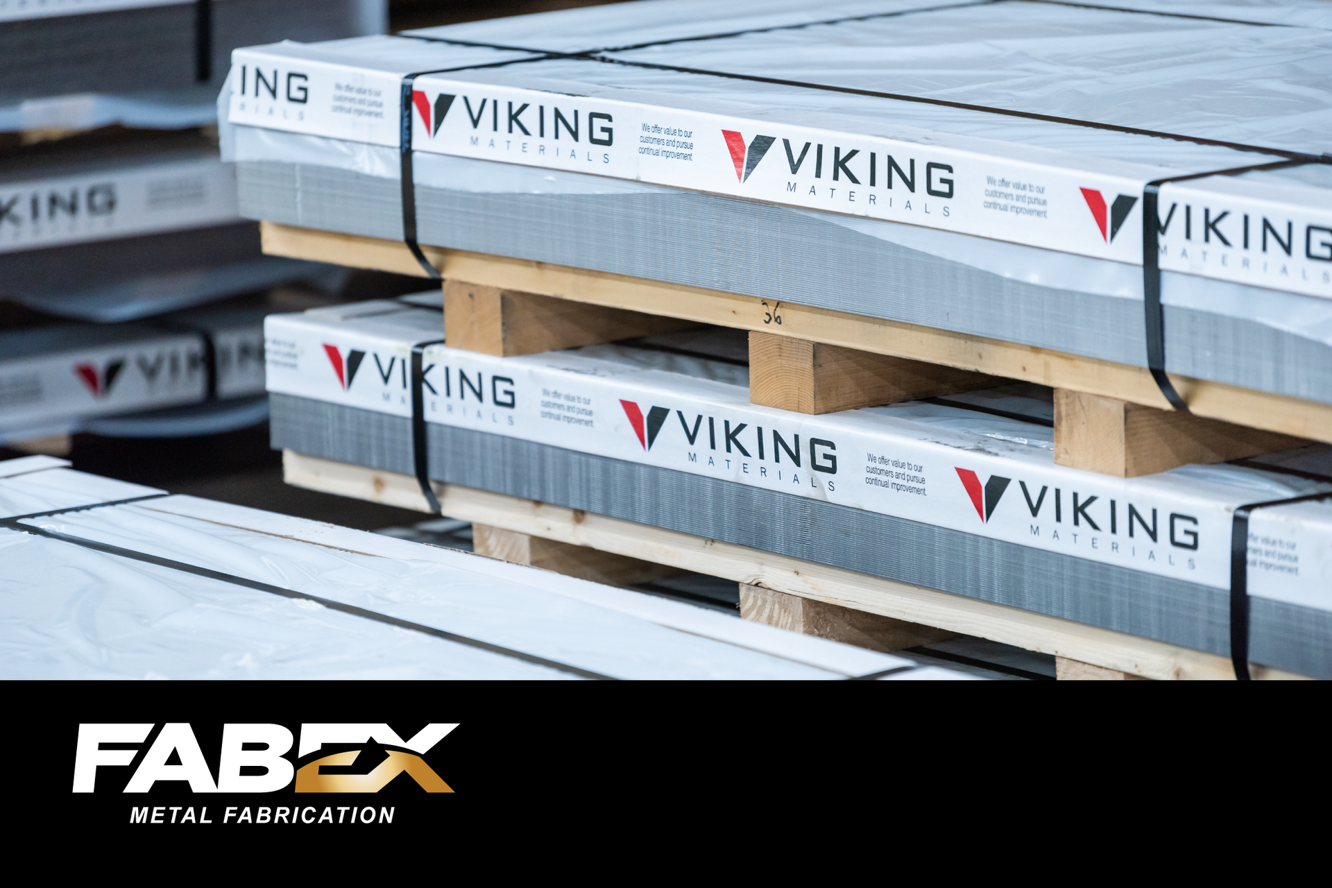 Stacked metal panels wrapped on wooden pallets, with Viking and Fabex branding visible.