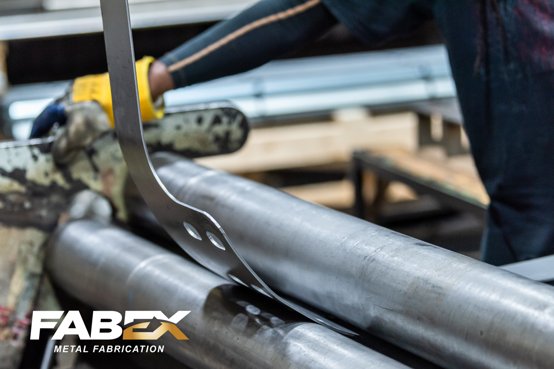 Worker welding metal pipes with sparks in an industrial setting