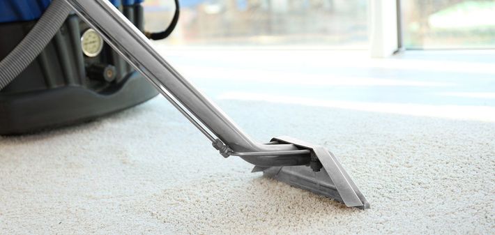 a vacuum cleaner is being used to clean a white carpet