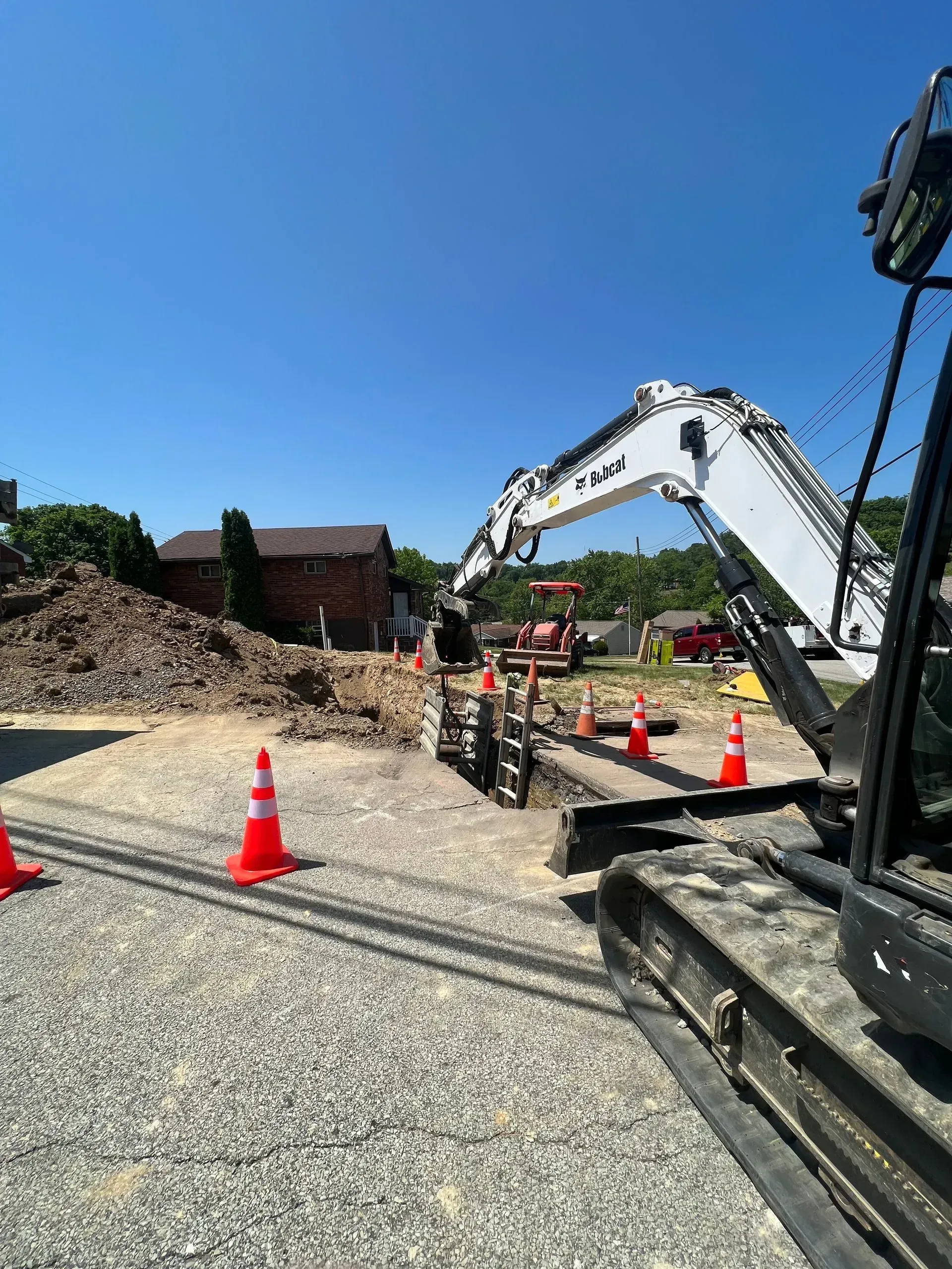 Construction site with an excavator and orange cones.