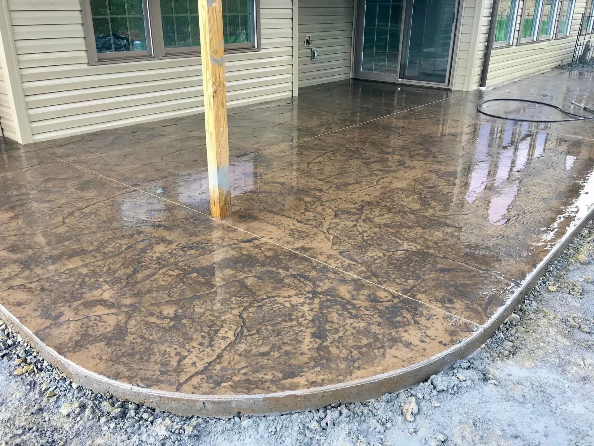 Stamped concrete patio with a brown, mottled finish.