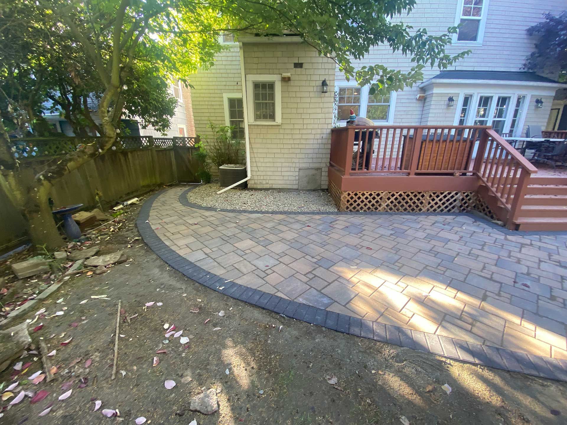 a patio with a deck and stairs at the back of the house