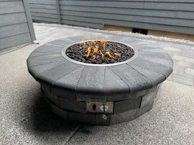 A fire pit is sitting on a patio in front of a house