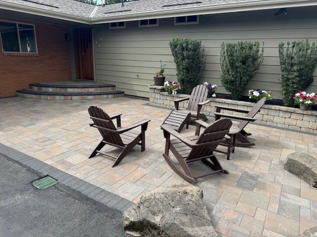 A patio with rocking chairs in front of a house