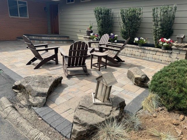 A patio with chairs, a table and a birdhouse in front of a house