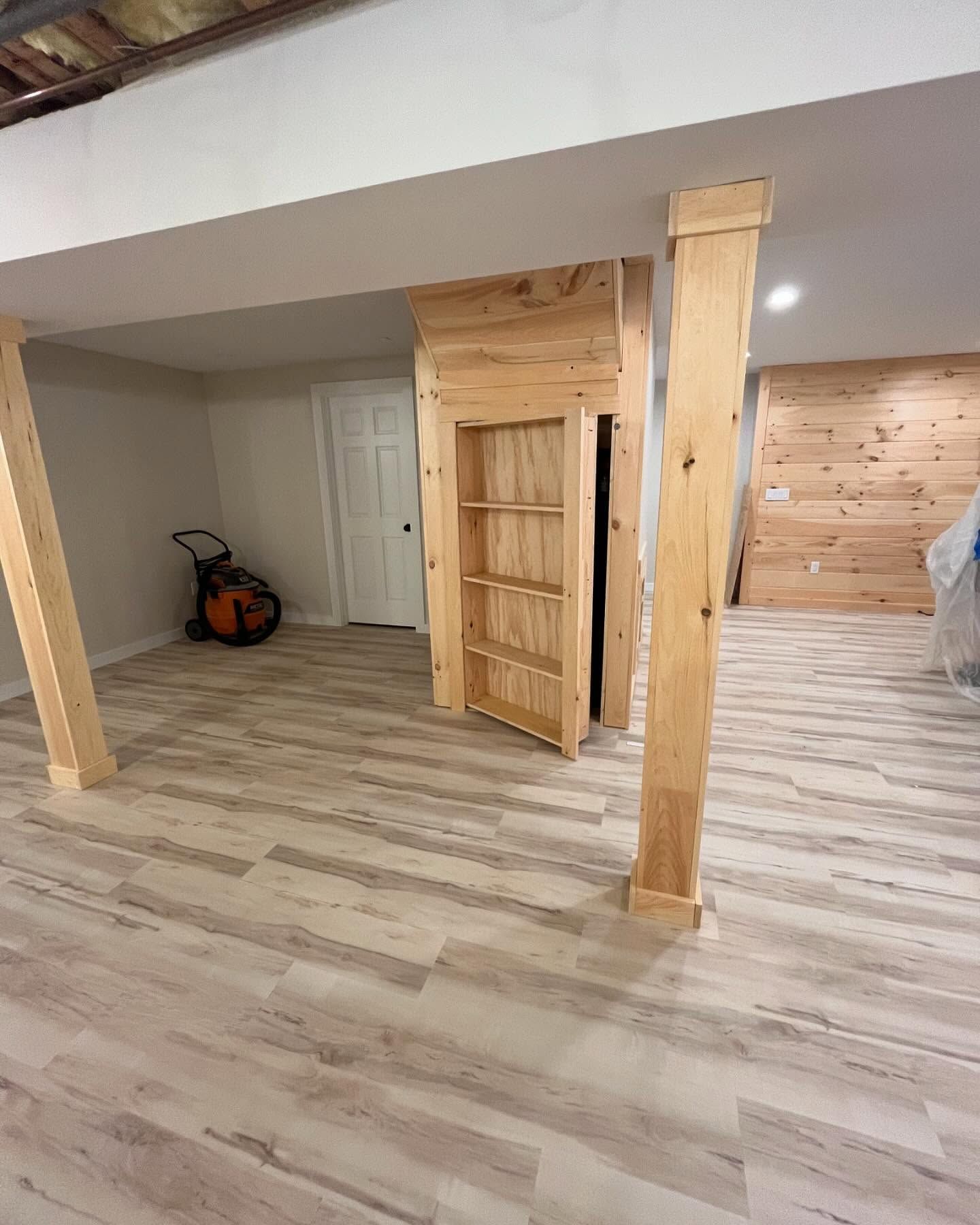 Interior room with light wood floors, a wooden divider, and a door in the background.