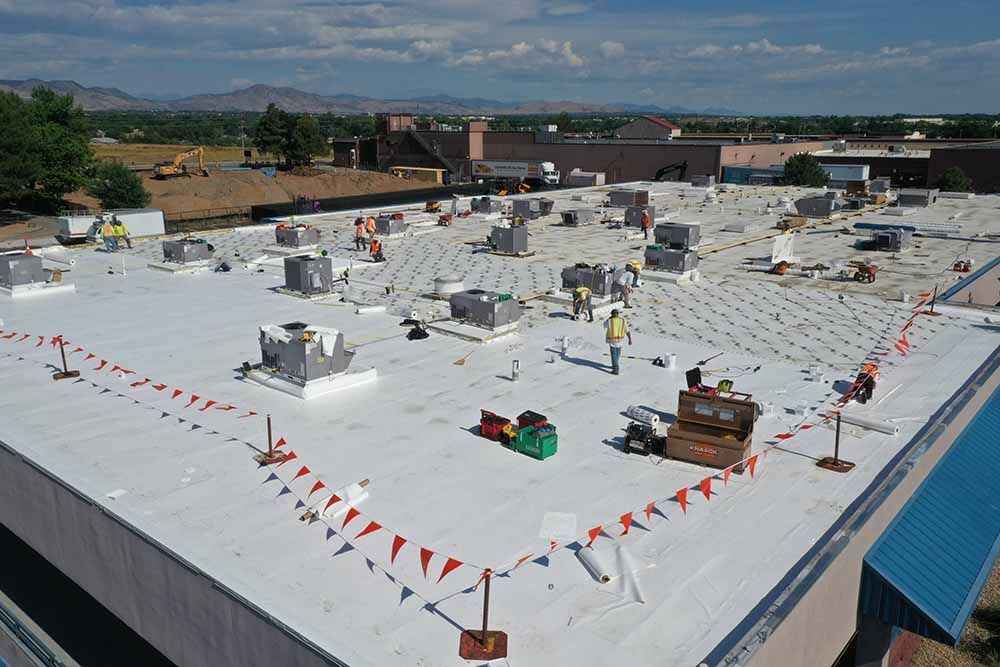 A group of people are working on the roof of a building.