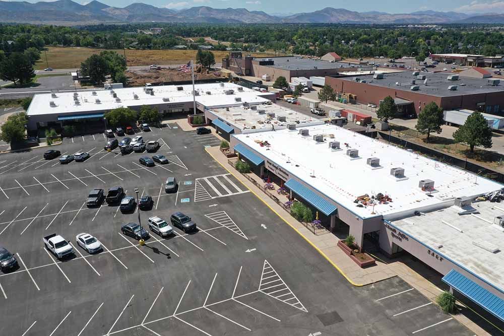 An aerial view of a shopping center with cars parked in front of it