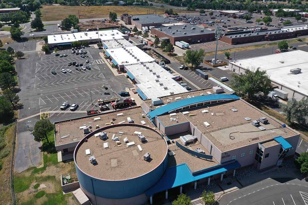 An aerial view of a large building with a blue roof