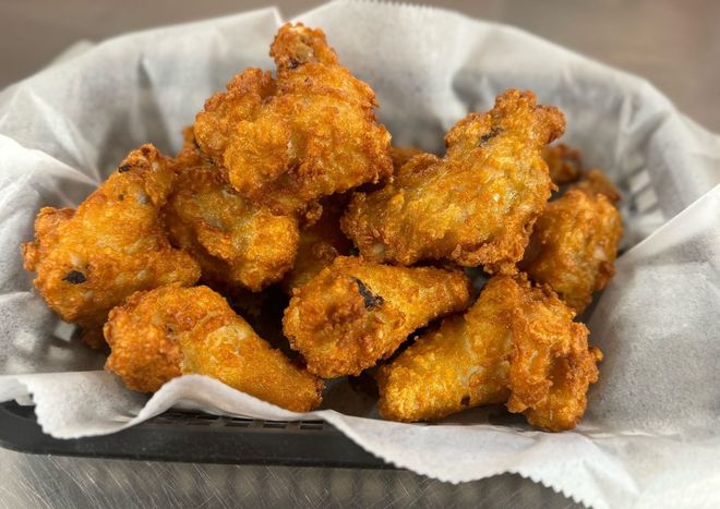 A basket filled with fried chicken wings on a table