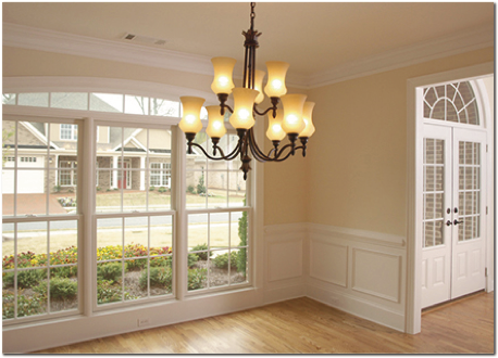 An empty dining room with a chandelier hanging from the ceiling