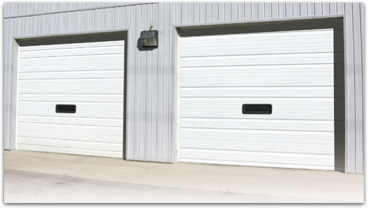 Two white garage doors on the side of a building