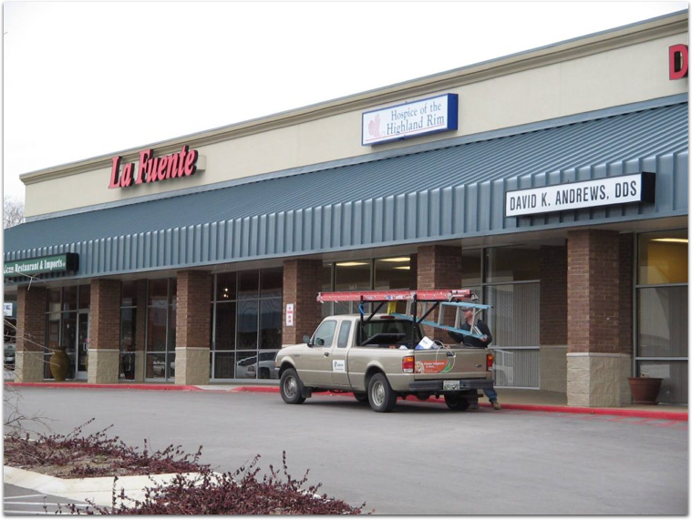 A truck is parked in front of a store called la fuente