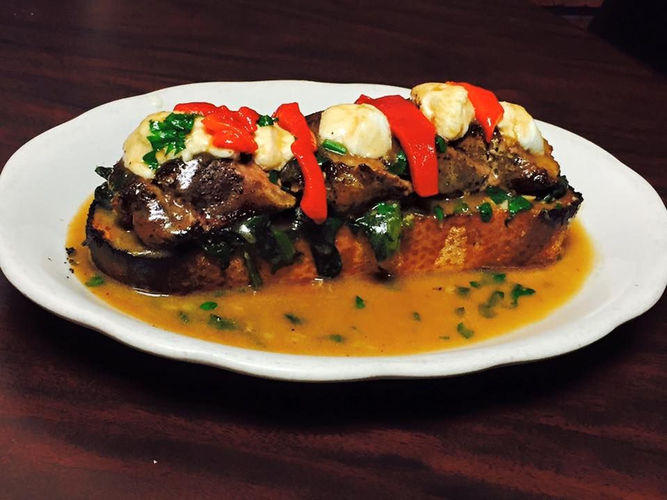 Eggplant and mushroom toast topped with red peppers and sauce.