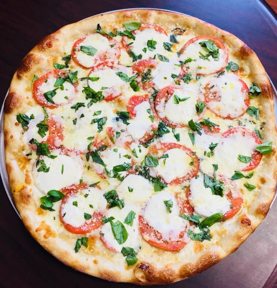 Margherita pizza: tomato, mozzarella, basil on a golden crust.