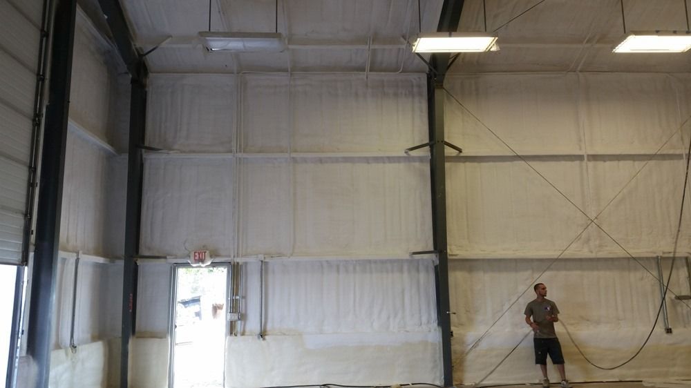Man in a warehouse shooting a basketball towards a hoop.