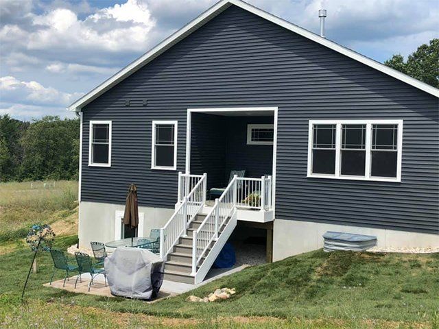 The back of a house with stairs leading up to it.
