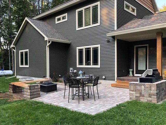 There is a table and chairs on the patio in front of the house.