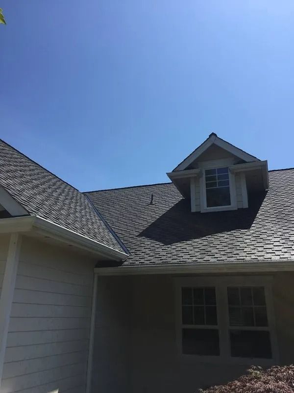 House roof and dormer under a clear blue sky
