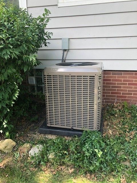 A york air conditioner is sitting on the side of a house.