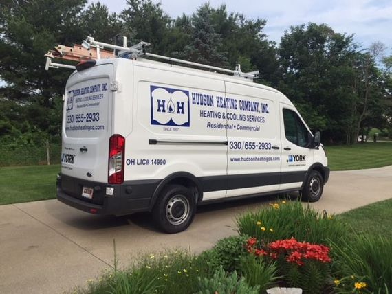 A white van is parked on the side of a road.