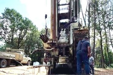 Man with water well drilling equipment