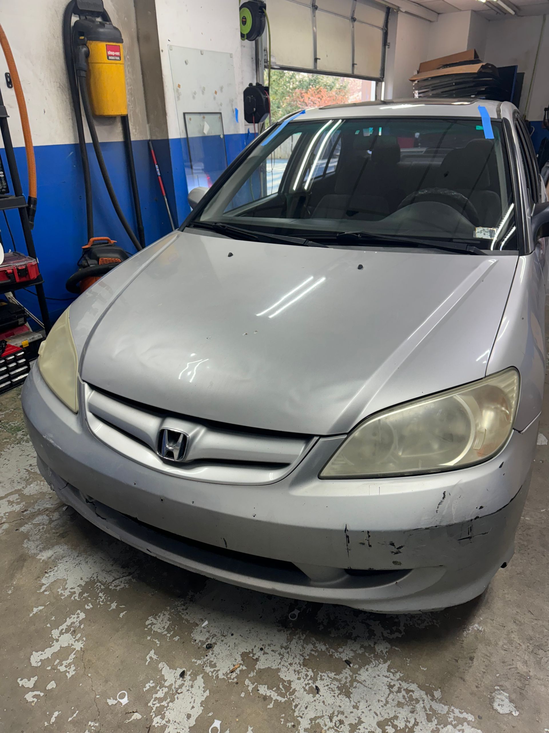a silver Honda Civic is parked in a garage