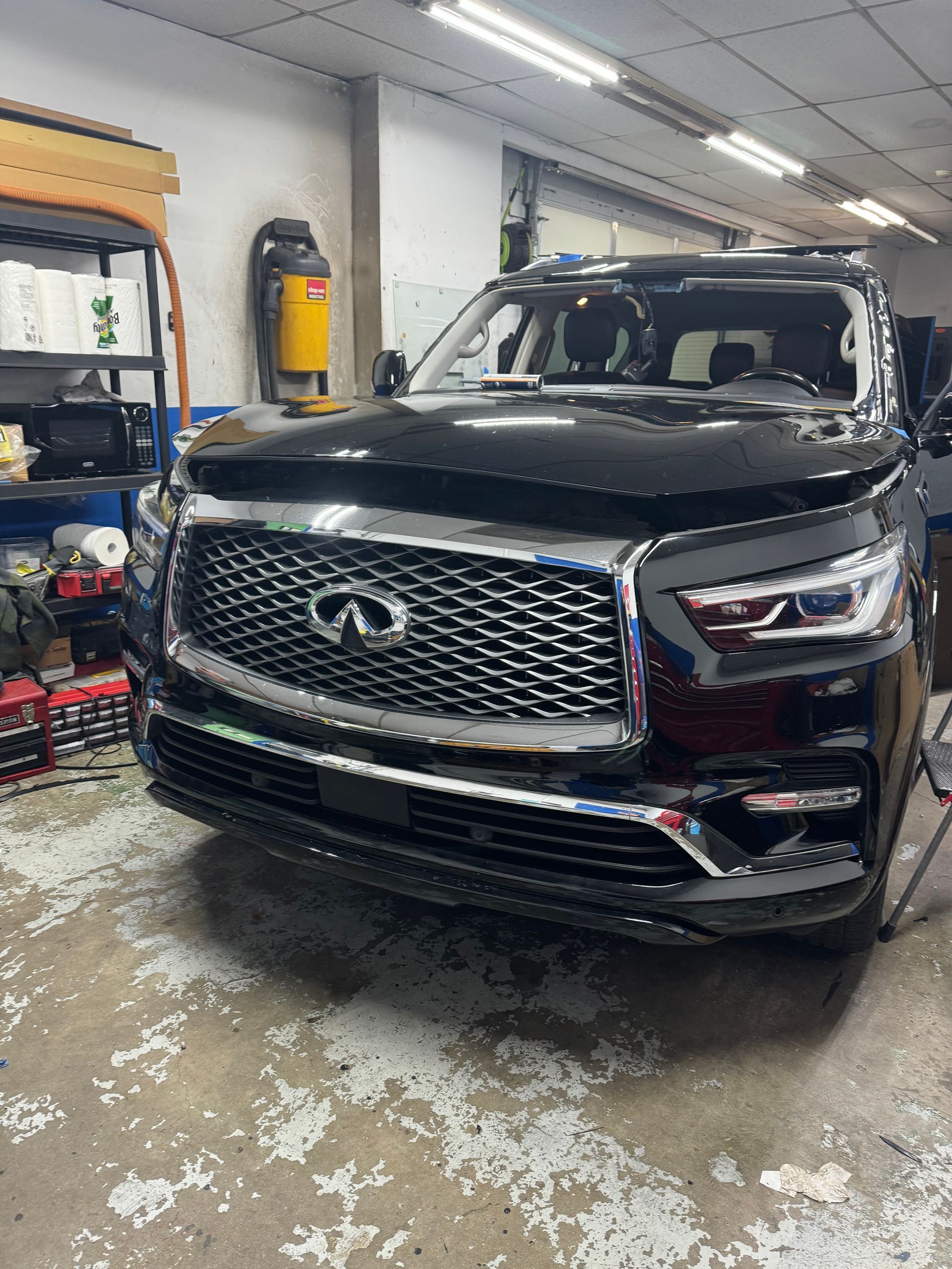 a black Infiniti QX80 is parked in a garage